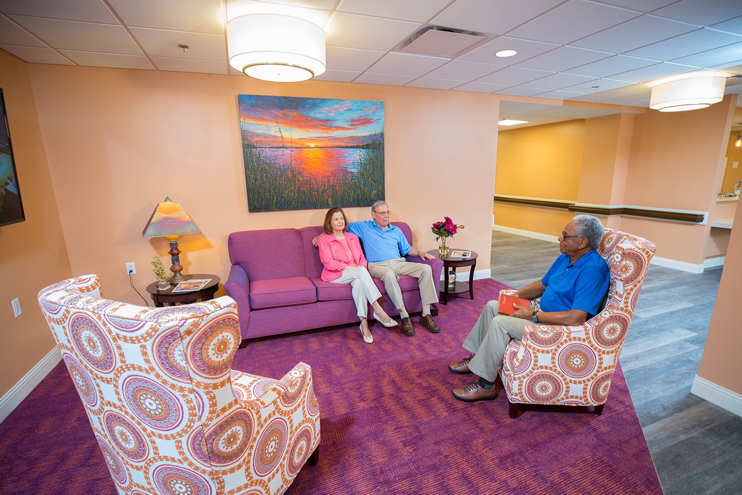 Group of rehab patients sitting together in a sitting room with a colorful couch and chairs