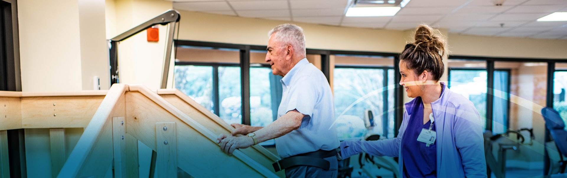 Trainer assisting rehab patient on exercise machine in the fitness center